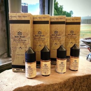 Royal Knight 皇家系列煙油擺放於戶外窗台石面，陽光灑落呈現自然與復古融合風格 　說明重點：窗邊陽光自然光源與石材質地突顯煙油瓶身與盒裝設計細節。